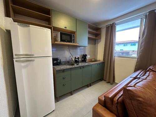 グァラトゥバにあるFlamingo Pé na areia - Centro/Guaratubaのキッチン(白い冷蔵庫付)