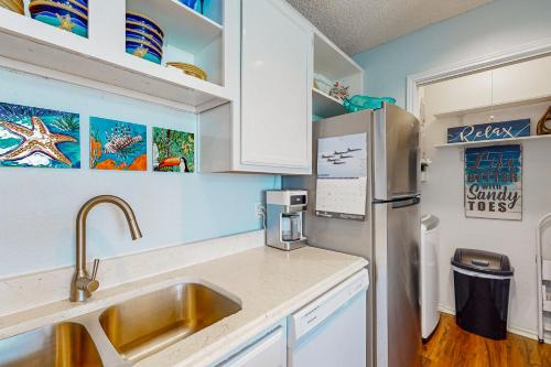 a kitchen with a sink and a refrigerator at Beach Club 323 in Padre Island