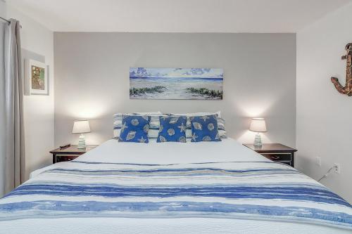 Un dormitorio con una cama azul y blanca con dos lámparas. en Nelray Shores at Seamist Condominiums, en Port Aransas