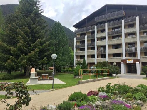 Un gran edificio con un parque enfrente. en Gemütliche Ferienwohnung Im Disentiserhof, en Disentis