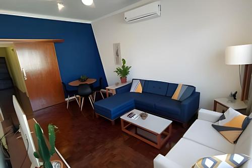 un salon avec un canapé bleu et une table dans l'établissement Casa familiar 2 qts, próx. ao Santuário Nacional, à Aparecida