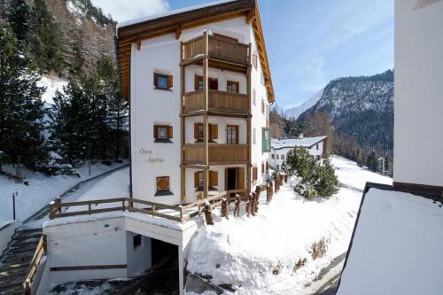 un immeuble avec un balcon sous la neige dans l'établissement Chesa Aquileja Trüb, à Pontresina