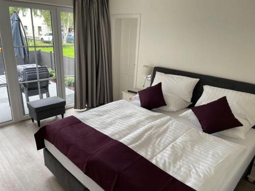 a bedroom with a large bed and a balcony at Seaside-Amrum-5 in Norddorf