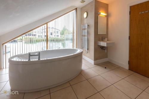 a large bathroom with a tub and a sink at Waters Edge 16, Heron Lodge in South Cerney