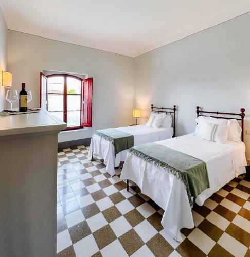 a bedroom with two beds and a checkered floor at RICASOLI, Brolio Agriroom in Gaiole in Chianti