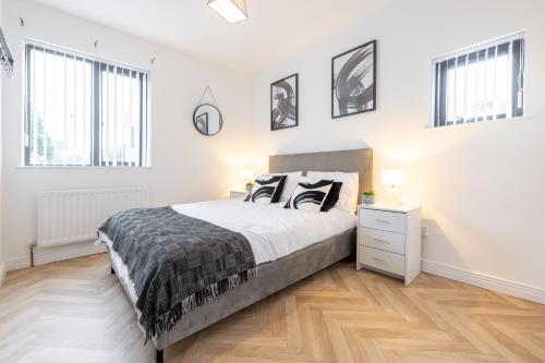 une chambre blanche avec un lit et deux fenêtres dans l'établissement Foyle View Retreat, à New Buildings