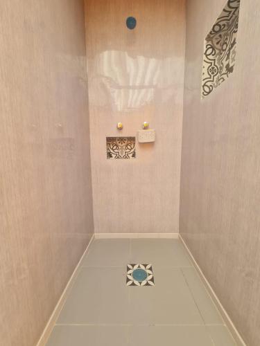 a bathroom with a shower with a tile floor at Hostal Casa Gavilán