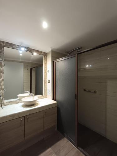 a bathroom with a sink and a large mirror at Hotel Colonos Los Angeles in Los Ángeles