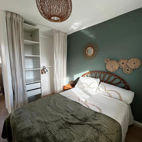 a bedroom with a bed and a green wall at Appartement T2 - proche mer - balcon ensoleillé in Six-Fours-les-Plages