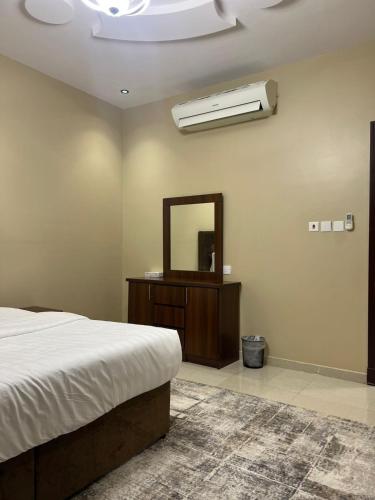 a bedroom with a bed and a mirror and a fan at سويت غرفتين وصالة مميز in Jeddah
