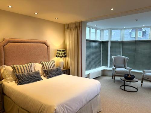 a bedroom with a large bed and a chair at The Sunningdale in Bamburgh