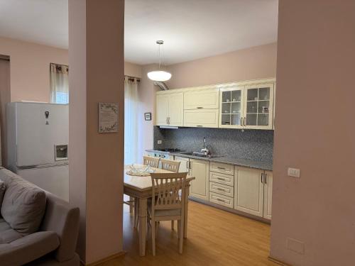 une cuisine avec une table et des placards blancs dans l'établissement Urban Apartment, à Tirana