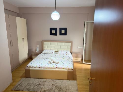 - une chambre avec un grand lit et un couvre-lit blanc dans l'établissement Urban Apartment, à Tirana