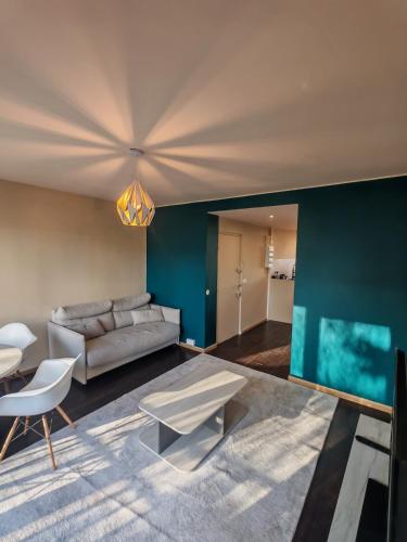 a living room with a couch and a table at La Fresque in Vélizy-Villacoublay