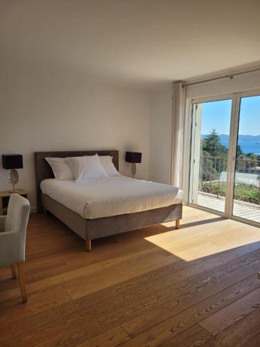 a bedroom with a bed and a large window at La Villa in Sainte-Maxime