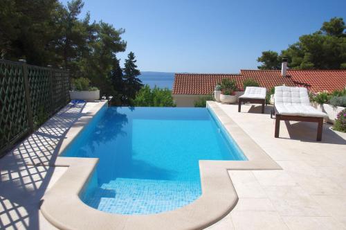 einen Pool mit blauem Wasser im Hinterhof in der Unterkunft Ferienhaus für 8 Personen ca 110 qm in Sumartin, Dalmatien Mitteldalmatien in Sumartin