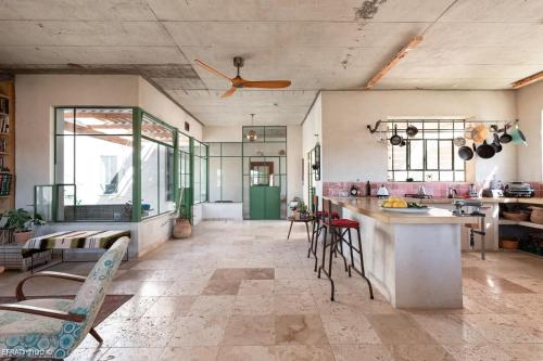 eine Küche mit einer Theke und Stühlen in einem Zimmer in der Unterkunft הבית האנדלוסי in H̱aẕeva