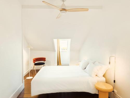 a bedroom with a white bed with a ceiling fan at Friendly Hills Bairro Alto in Lisbon