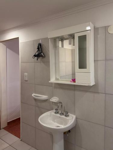 a white bathroom with a sink and a mirror at Babela 1 in Concordia