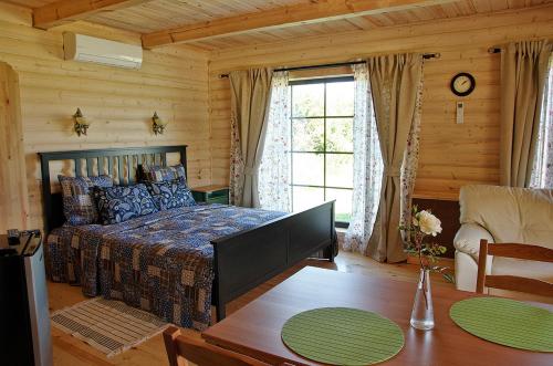 プシュキンスキエ・ゴリにあるU Lukomoryaの木製の部屋にベッド1台が備わるベッドルーム1室があります。