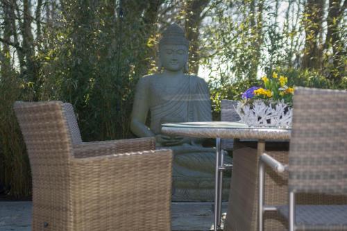 a statue sitting next to a table and chairs at Ferienhaus In Niebüll Mit Großer Terrasse in Niebüll