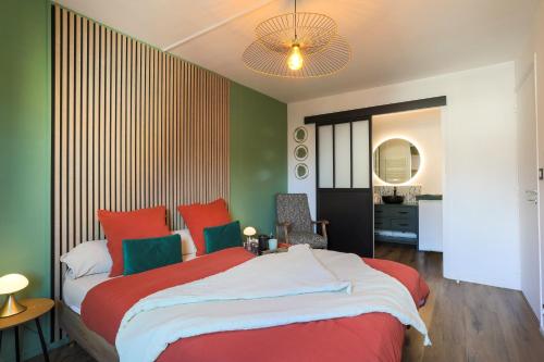 a bedroom with a large bed with red and green at Appartement magnifique à Paimpol in Paimpol