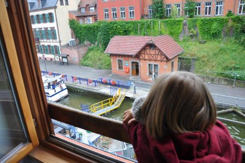 a young girl looking out of a window at a river at L'écluse de Saverne in Saverne