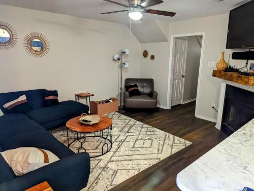 a living room with a blue couch and a fireplace at 3 Bed Townhouse with King Bed Mins from Downtown in Shreveport