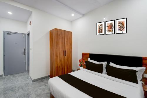 SurūrnagarTownhouse Oak L B Nagar Metro Station的一间卧室配有一张大床和一个木制橱柜