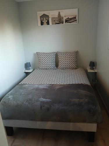 un lit dans une chambre avec deux tables de nuit dans l'établissement La Cabane du bois l'abbé, à Saint-Martin-Boulogne