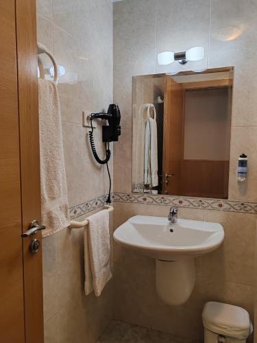 a bathroom with a sink and a mirror and a toilet at Hostal Ponte Dos Santos in Ribadeo