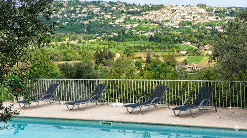 een groep stoelen naast een zwembad bij Villa la Grette in Fayence