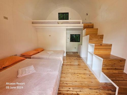 a room with two beds and a staircase at Alcasas Resort in Duero