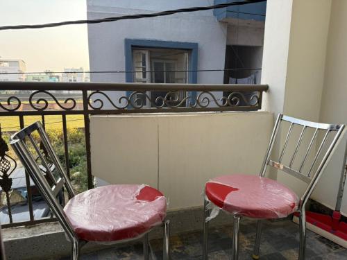 twee stoelen bovenop een balkon bij Hotel Sacred Roots in Rishīkesh