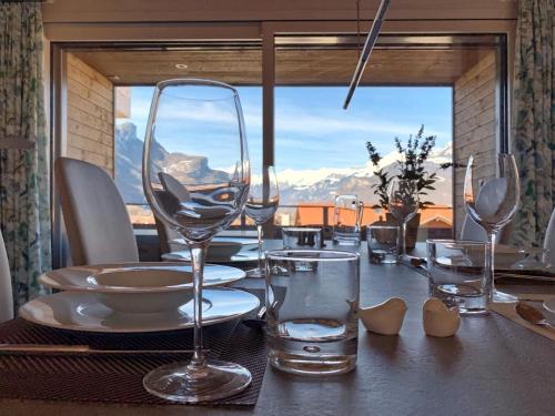 a table with wine glasses on a table with a view at Mountain 4U in Meiringen