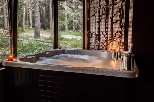 a large bath tub with a window in a bathroom at Hotel Restaurant 6ATO RiLa in Panichishte