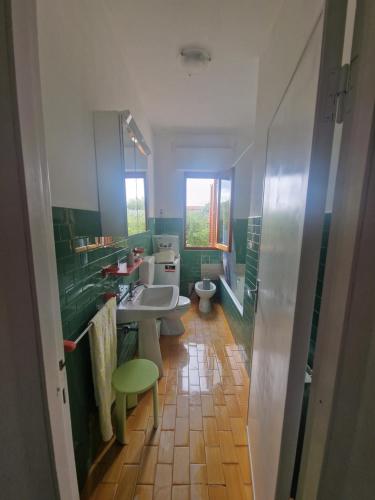 a bathroom with two toilets and a sink and a mirror at CasaMiria in Seravezza