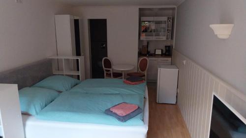 ein kleines Schlafzimmer mit 2 Betten und eine Küche in der Unterkunft Appartements Haus Hashagen in Oerlinghausen