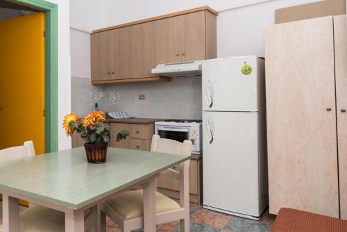 a kitchen with a table and a white refrigerator at Villa Maria in Kokkari