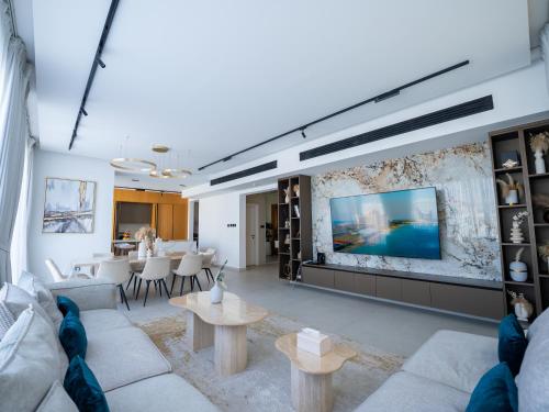 a living room with white furniture and a flat screen tv at Luxurious Villa 5BHK with Pool BBQ and Full Time Housemaid Assistance - live in in Dubai