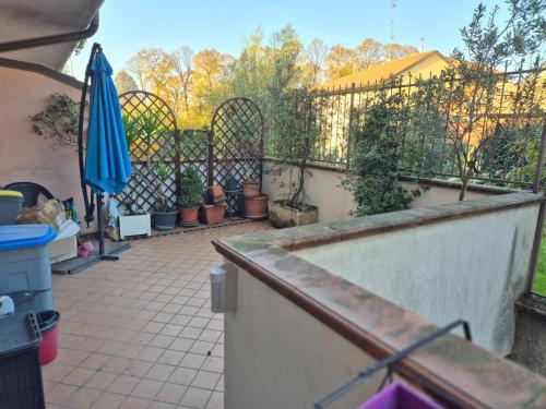 a patio with potted plants and an umbrella at Le Principesse di Rho, vicinanze Milano e fiera in Rho