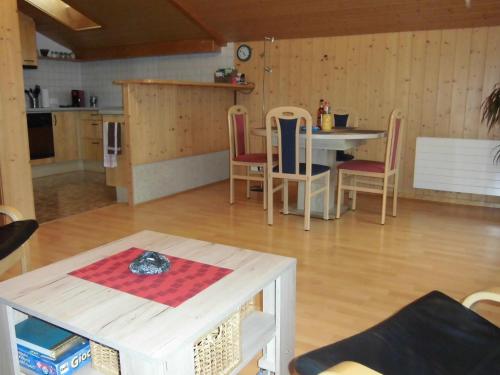 eine Küche und ein Esszimmer mit Tisch und Stühlen in der Unterkunft Ferienwohnung Nägeliplatten - b48644 in Hasliberg