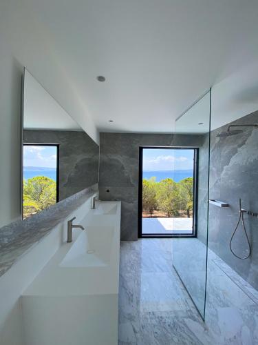 a bathroom with a shower and a glass window at Kilada on the Rocks in Kilada