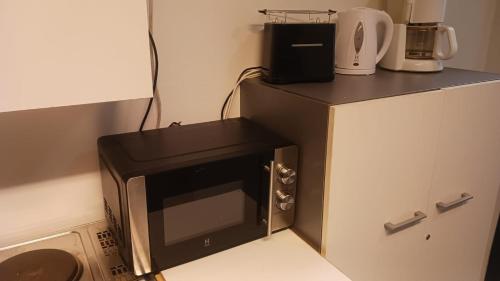 a microwave sitting on top of a counter in a kitchen at Cozy economy room for 2 persons at the shopping area in Rovaniemi