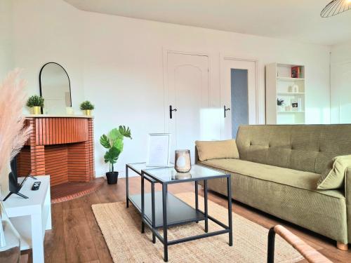 een woonkamer met een bank en een tafel bij Le Sweet Escape - Vue Sur La Cathédrale in Beauvais