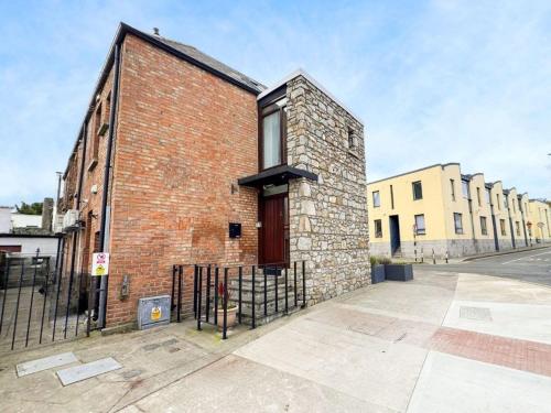 Un edificio de ladrillo con una puerta en el costado. en Unique Duplex Apartment in the heart of Dalkey with 2 Luxurious Bedrooms, en Dalkey
