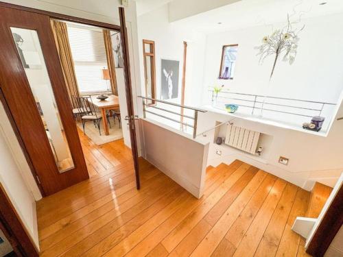 Una sala de estar con escalera y suelo de madera. en Unique Duplex Apartment in the heart of Dalkey with 2 Luxurious Bedrooms, en Dalkey