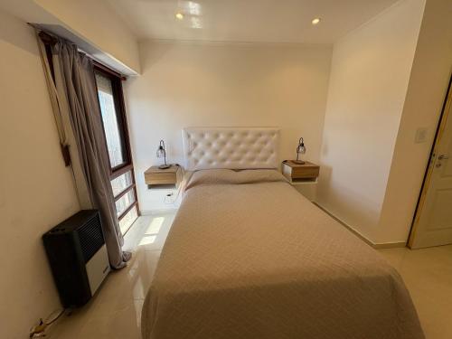 a bedroom with a large bed and a television at Aires del Mar in Santa Teresita