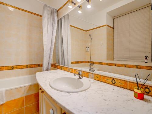 une salle de bain avec un lavabo, une baignoire et un miroir dans l'établissement Authentic Old Riga Heritage, 2BR, Grand Ceilings, à Tīnūži