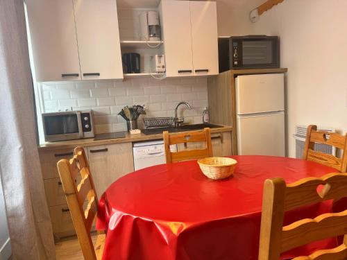 d'une cuisine avec une table et un chiffon rouge. dans l'établissement Osciere Ski in - Out, à Val Thorens